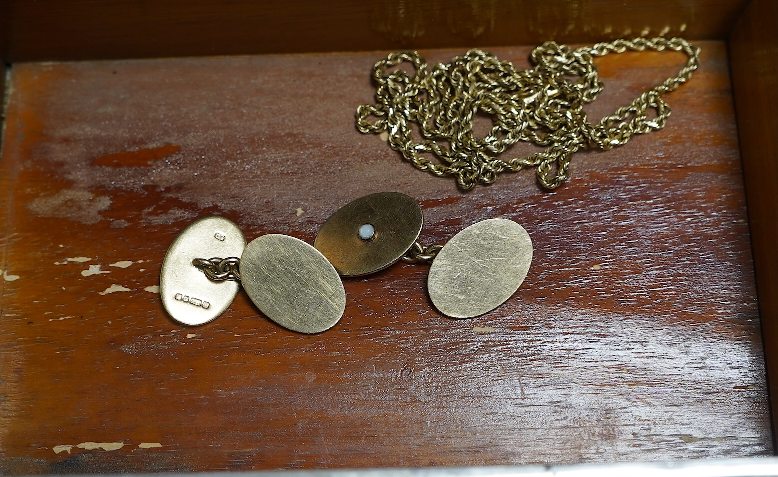 A pair of 9ct gold and seed pearl cufflinks, each end of oval outline, two accented with half pearls, to chain link connections, each end 1.9 x 1.3cm, British hallmarks, date letter for 1991, gross weight approximately 9